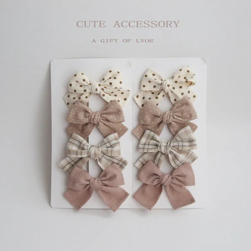 Set of children's fabric hairclips with dovetail bows in eight different colours and patterns.
