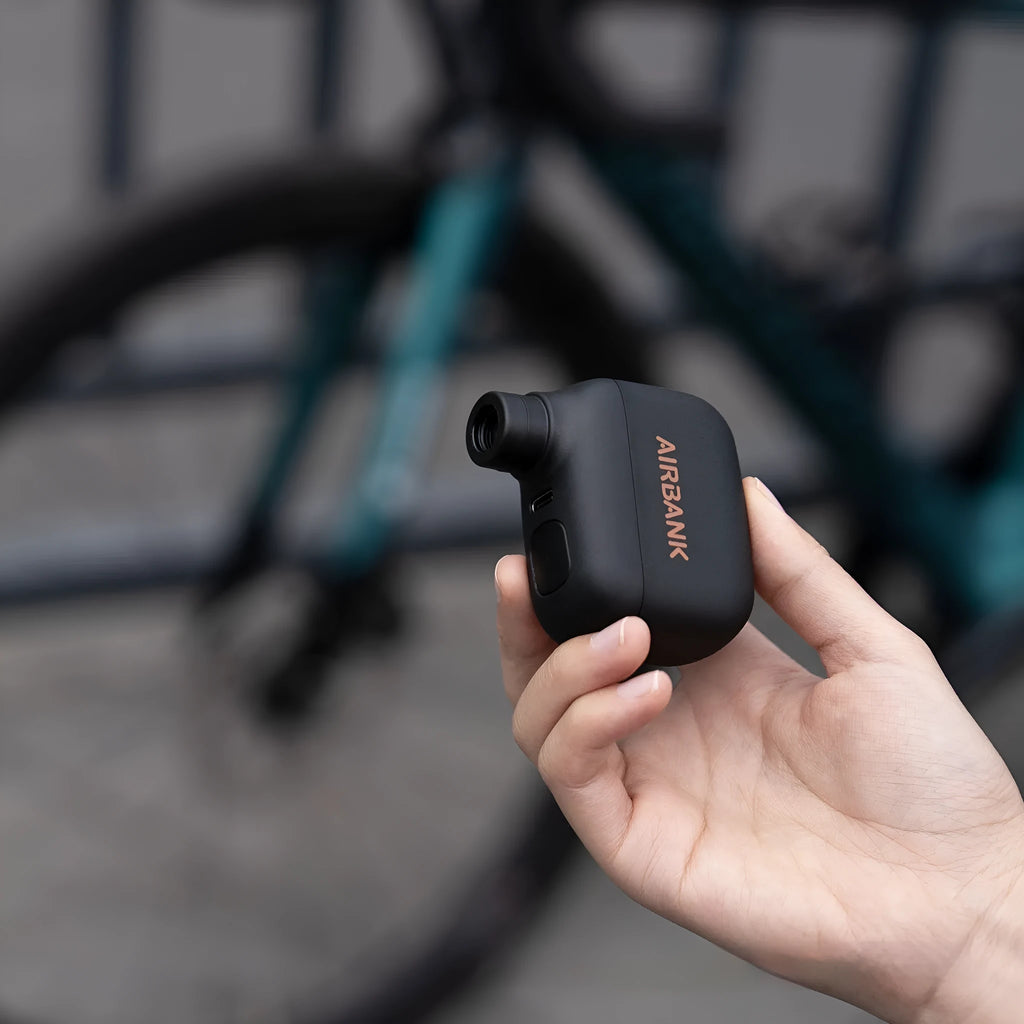Black mini electric bicycle pump with USB cable and waterproof bag