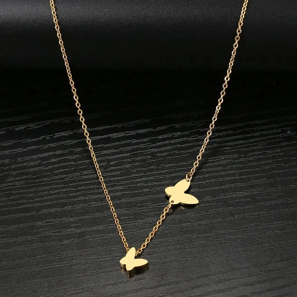 Butterfly pendant necklace in stainless steel with 18K gold electroplated finish on a white background