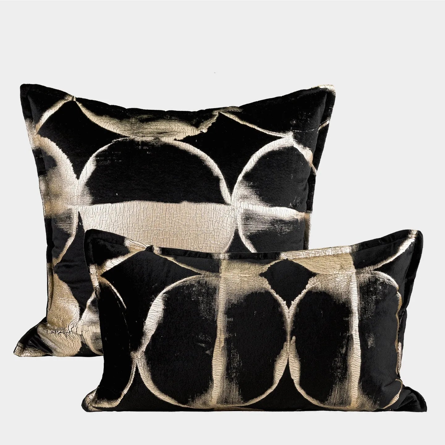 Black and gold abstract print flannel decorative cushion pillow on a sofa.