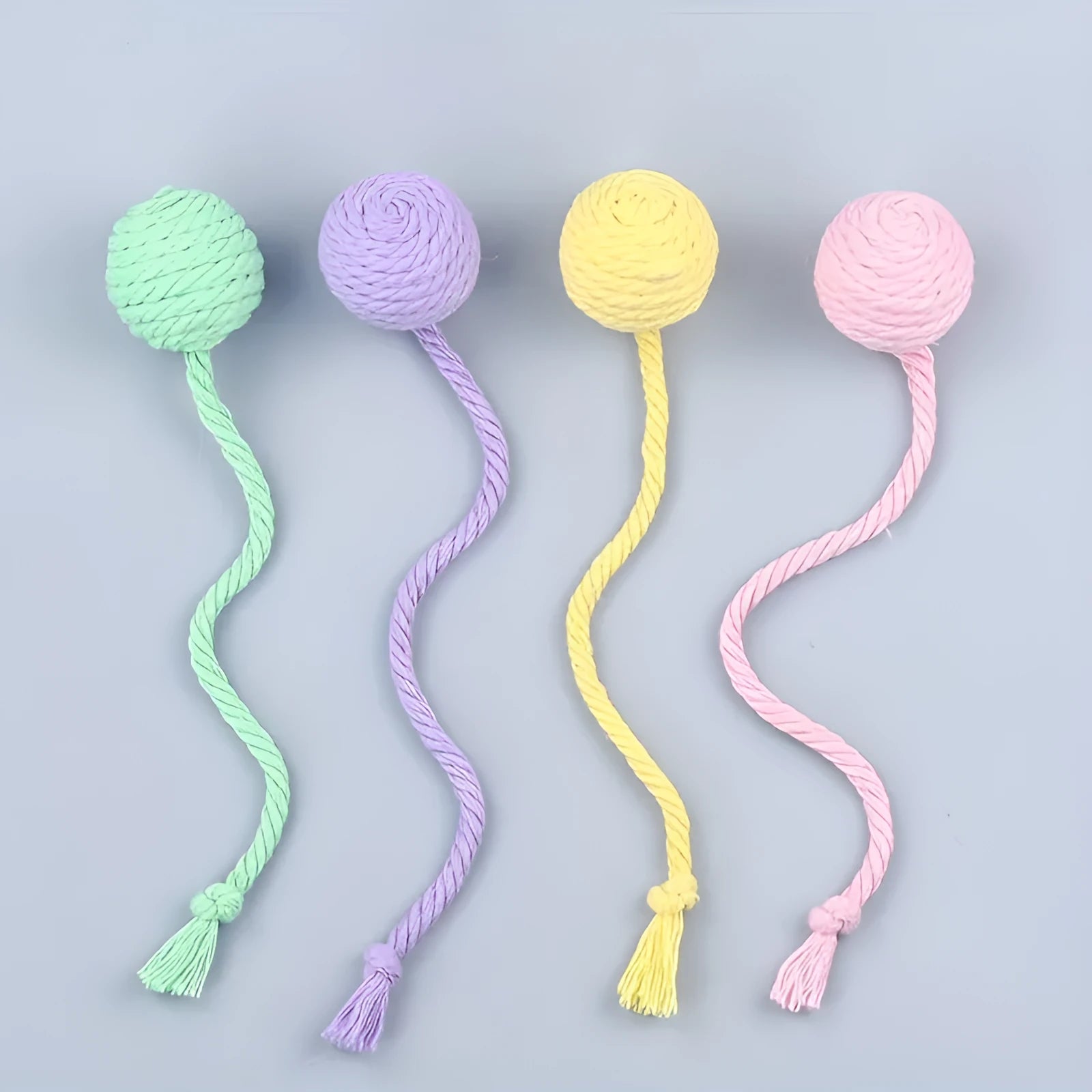 Cat toy ball with attached rope and bell in green, pink, purple or yellow colours showing 6cm and 3cm size comparison