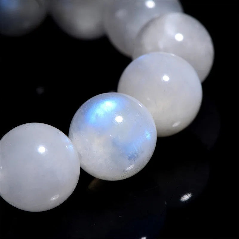 Natural blue moonlight round bead moonstone bracelet on a wrist, showing polished geometric beads.