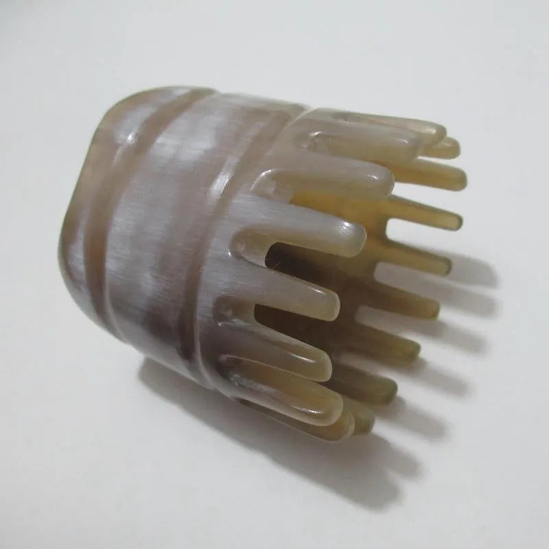 Black and white buffalo horn comb with wide teeth and a pointed end for hair massage and detangling.