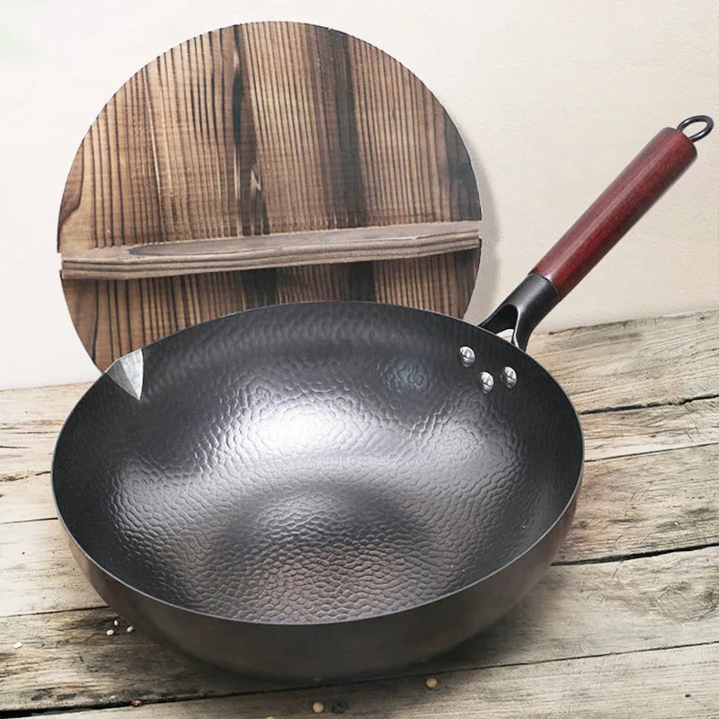Traditional black iron wok with long wooden handle measuring 32cm diameter