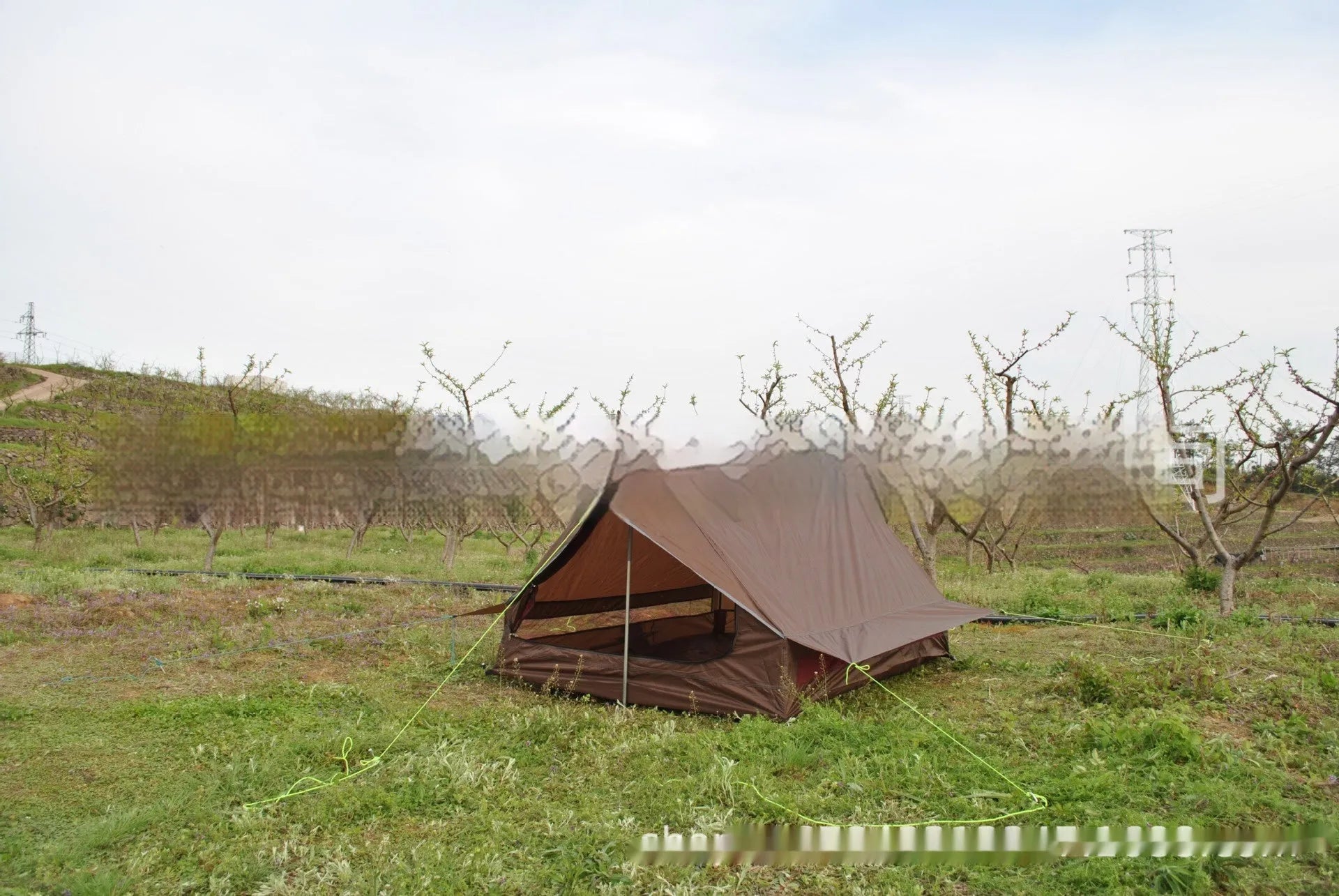 Brown or white A-frame pole-free cabin tent erected with hiking cane supports