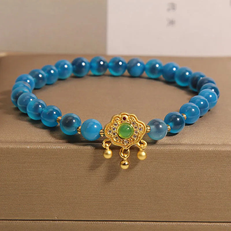 Blue agate safety lock pendant on a women's crystal bracelet with alloy-inlaid gemstones and rhinestones.