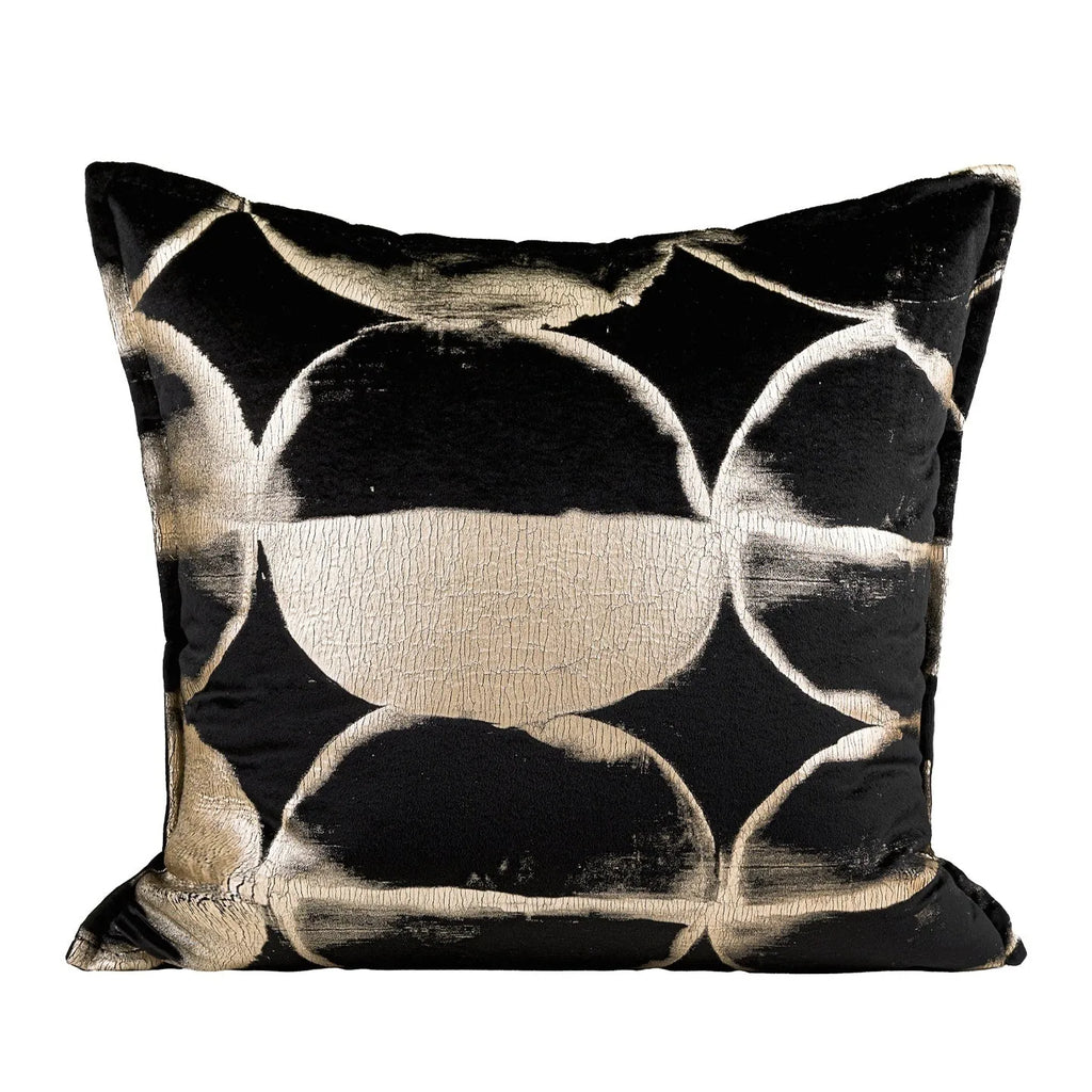 Black and gold abstract print flannel decorative cushion pillow on a sofa.