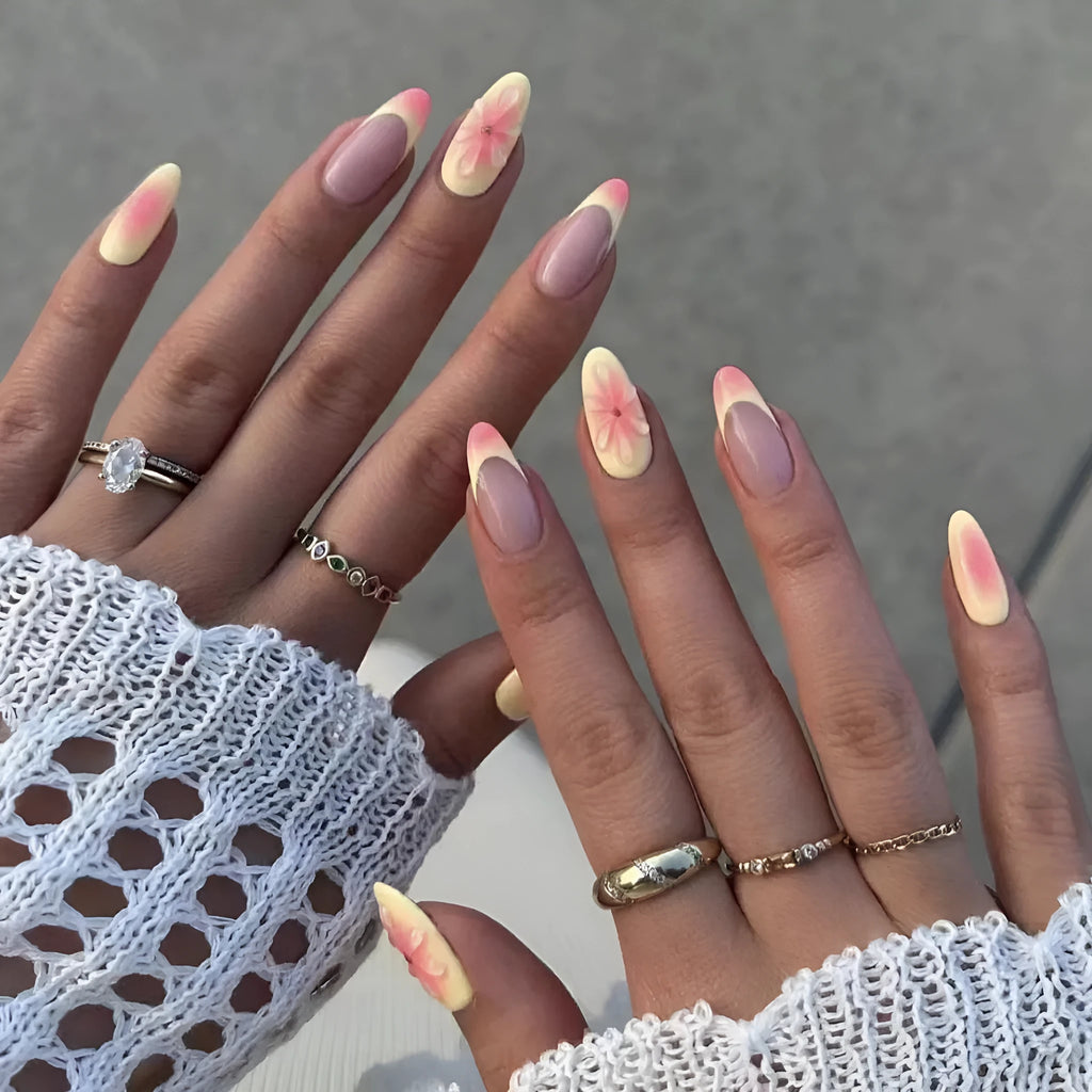 Fake nails set with white plastic armour pieces featuring raised pink and green cartoon flower designs.