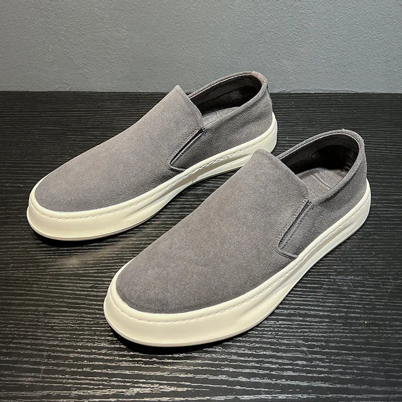 Men's grey slip-on casual shoes with round toe, mid-heel, and visible stitching on a rubber sole.
