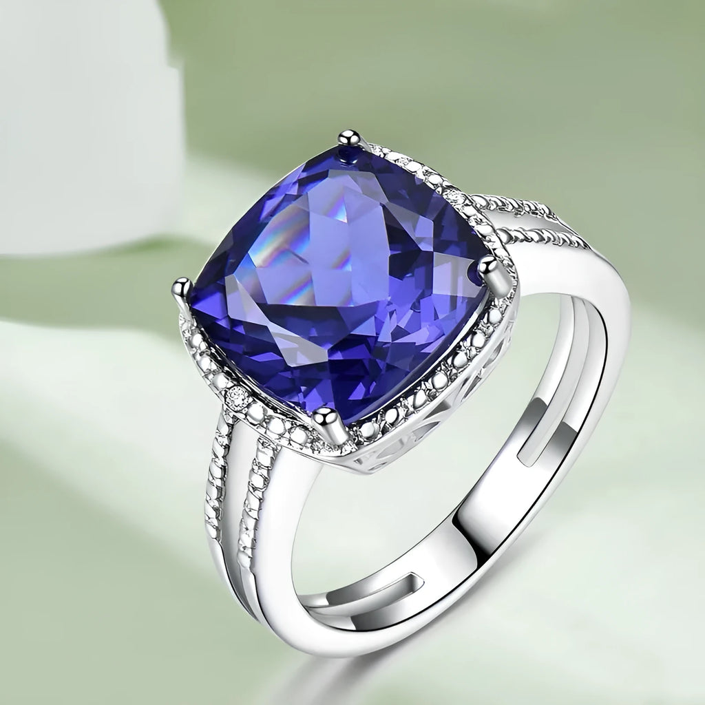 Blue Tanzanite stone set in a sterling silver 925 ring for women, shown on a finger.