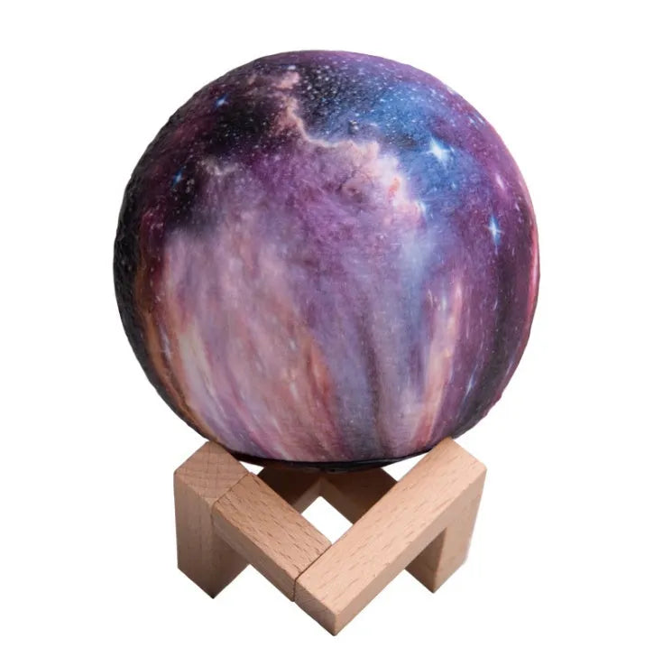 3D printed spherical lunar night light glowing with soft colour-changing LED light on a dark surface.
