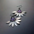 Close-up of purple bohemian drop earrings with animal zodiac design and resin gemstone details on alloy posts.