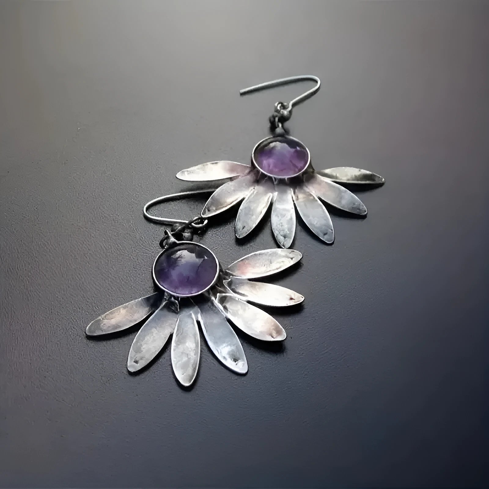 Close-up of purple bohemian drop earrings with animal zodiac design and resin gemstone details on alloy posts.