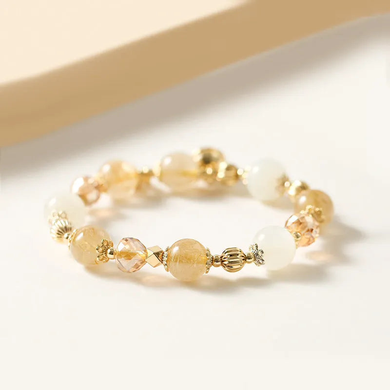 Gold electroplated bracelet with rutilated quartz crystals and a central ringing bell charm