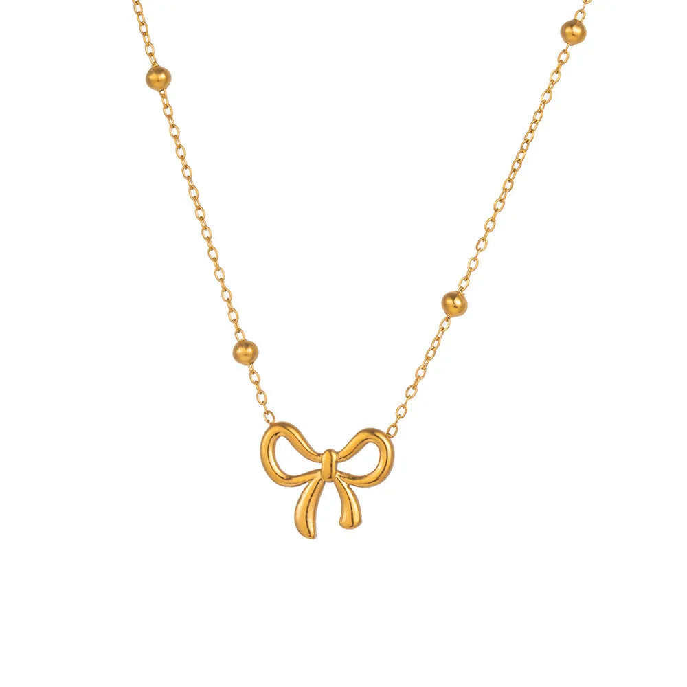 Gold bow necklace with adjustable cross chain on women's neck