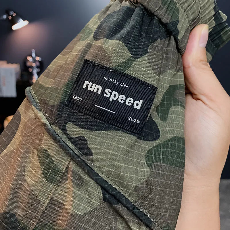 Men's camouflage pattern cargo shorts shown in loose knee-length fit on a mannequin