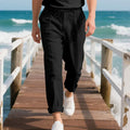 Man wearing light khaki linen casual trousers with a drawstring waist and straight leg.