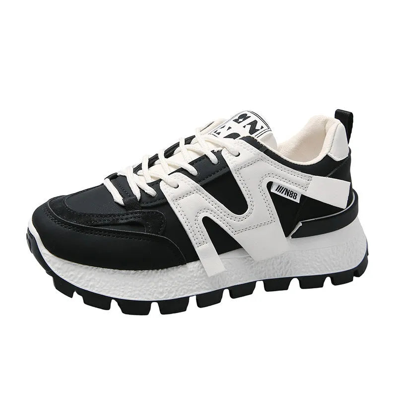 Low-top white and black casual sneakers with round toe and lace-up front