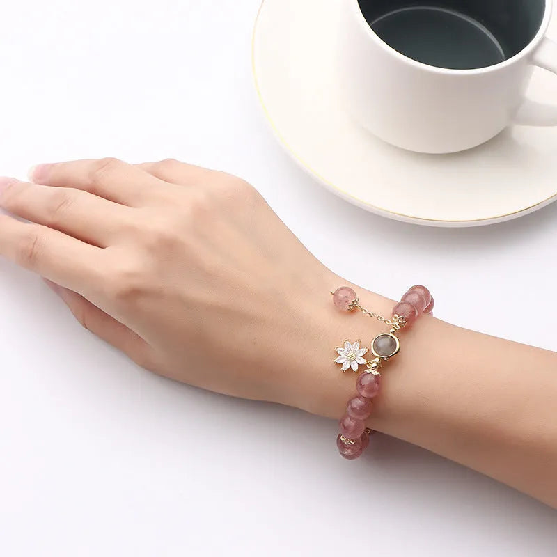 Mori style crystal bracelet with strawberry quartz stones and floral design details on a wrist.