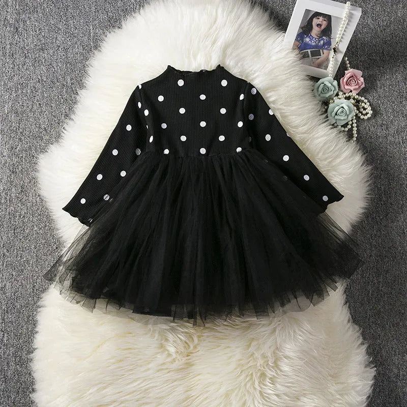 Baby girl in a long sleeve black tutu lace dress for a christening or birthday party.