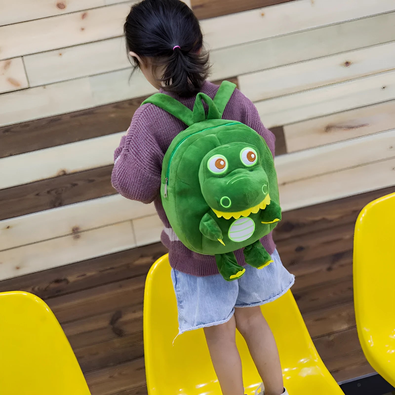 Soft blue dinosaur plush backpack for children with embroidered details and a soft handle.