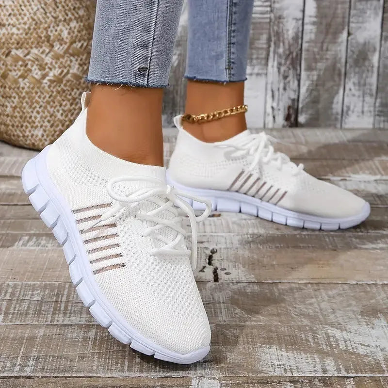 Breathable women's casual flat shoes in flying knit mesh with front lace tie.