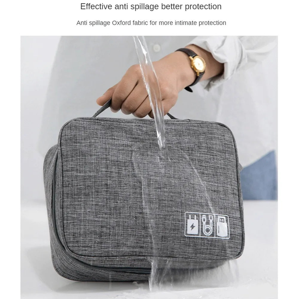 Black or grey waterproof travel cable organiser bag open to show mesh pockets and removable padded dividers.