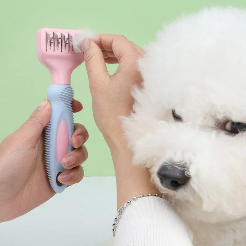 Pink dual-ended pet grooming brush with stainless steel knot knife and massage pins on a white background