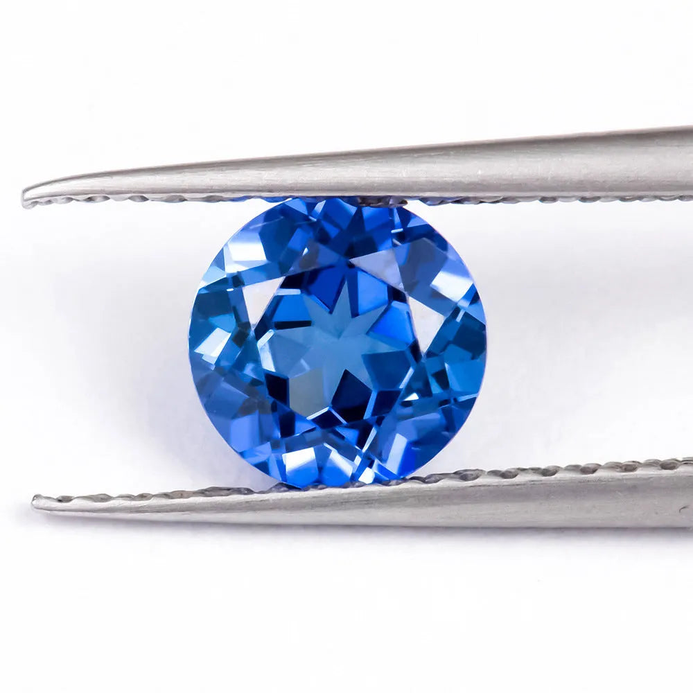 Royal blue cubic zirconia loose gemstone in a heart shape cut on a plain background.