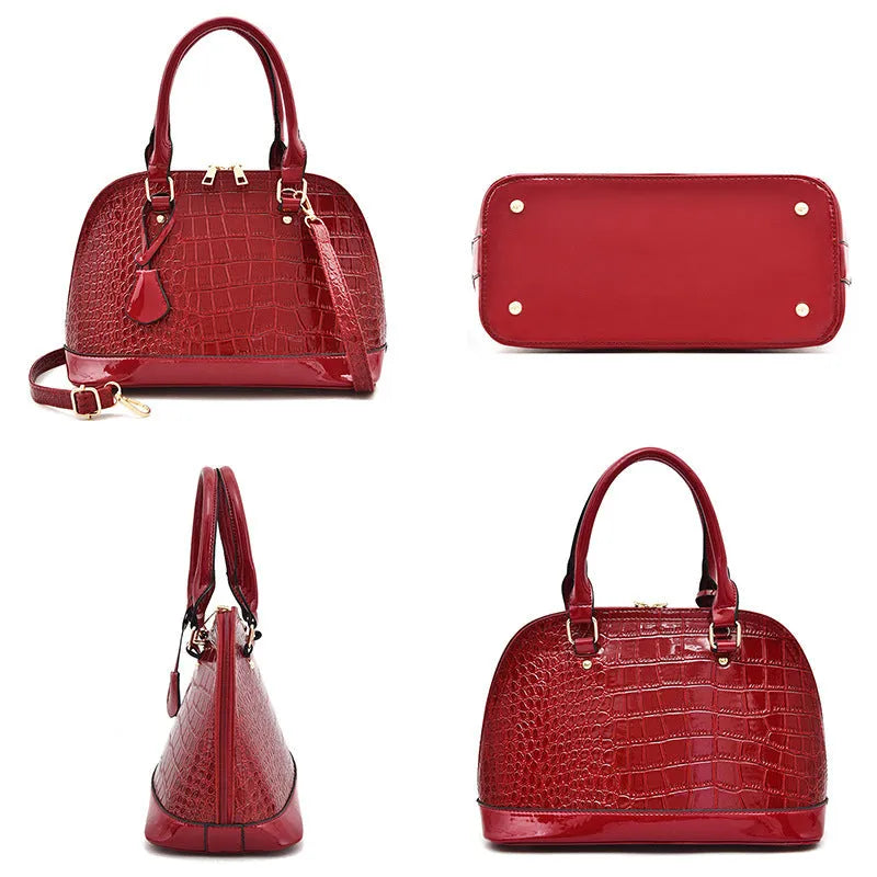 Large shiny black PU leather crossbody bag showing structured shell shape and shoulder strap.