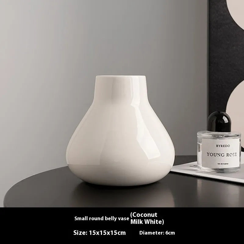 Ceramic round belly vase with coloured glaze finish in black or white, shown with artificial orchid stems