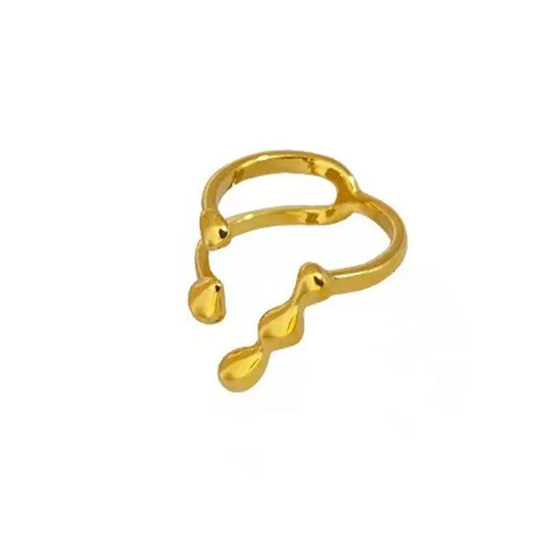 Open circle brass fashion ring with spherical beads in gold tone on a hand.