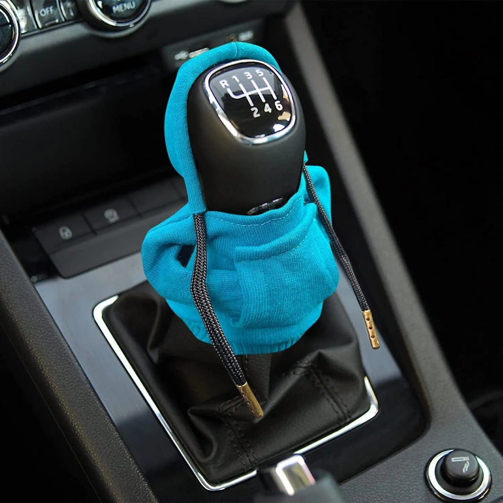 Cloth gear shift knob hoodie cover in assorted colours, shown next to a car gear stick.