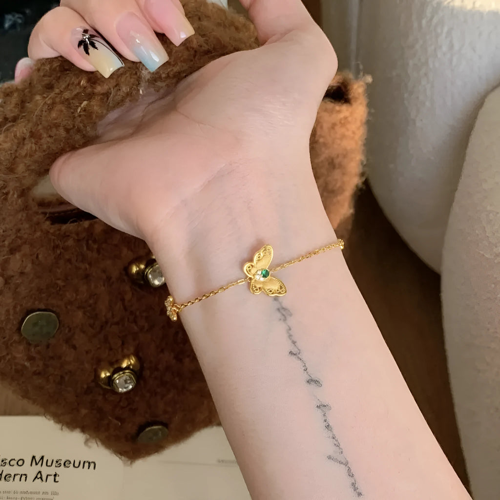 Gold copper hollow butterfly bracelet with wire drawing finish on display