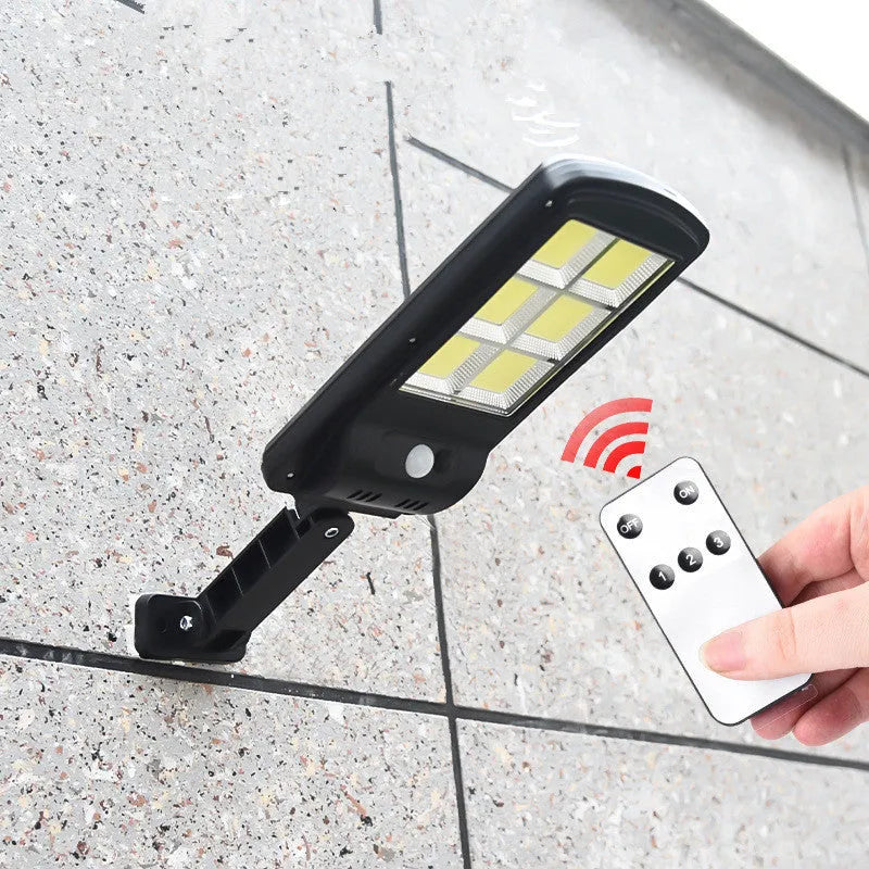 Black solar-powered outdoor wall light with motion sensor for garden and driveway security.