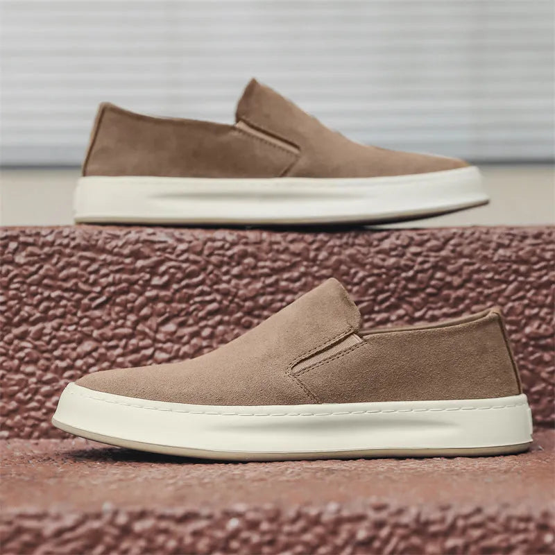 Men's grey slip-on casual shoes with round toe, mid-heel, and visible stitching on a rubber sole.