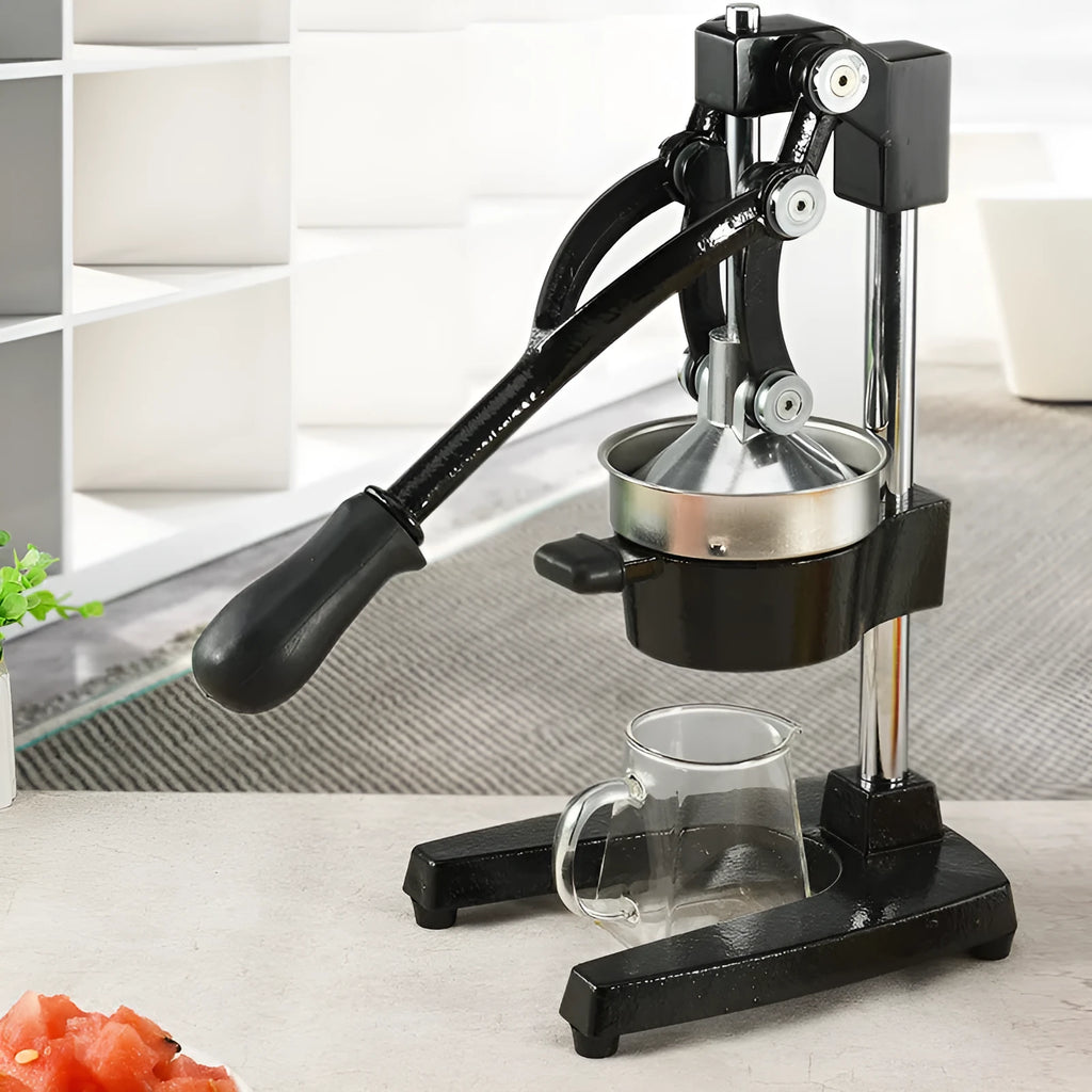 Black and white manual cast iron juice press with stainless steel funnel, 40cm tall.