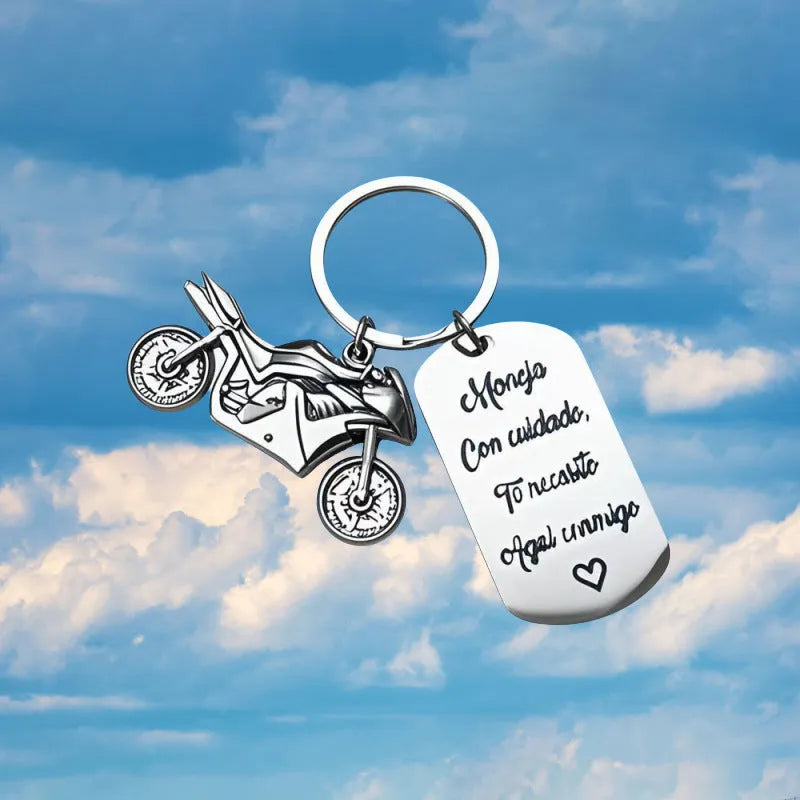 Stainless steel keychain with a motorcycle design presented on a velvet cloth.