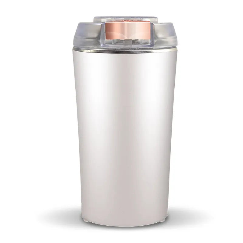 Compact blue mini flour mill and spice grinder made from stainless steel on a kitchen worktop.