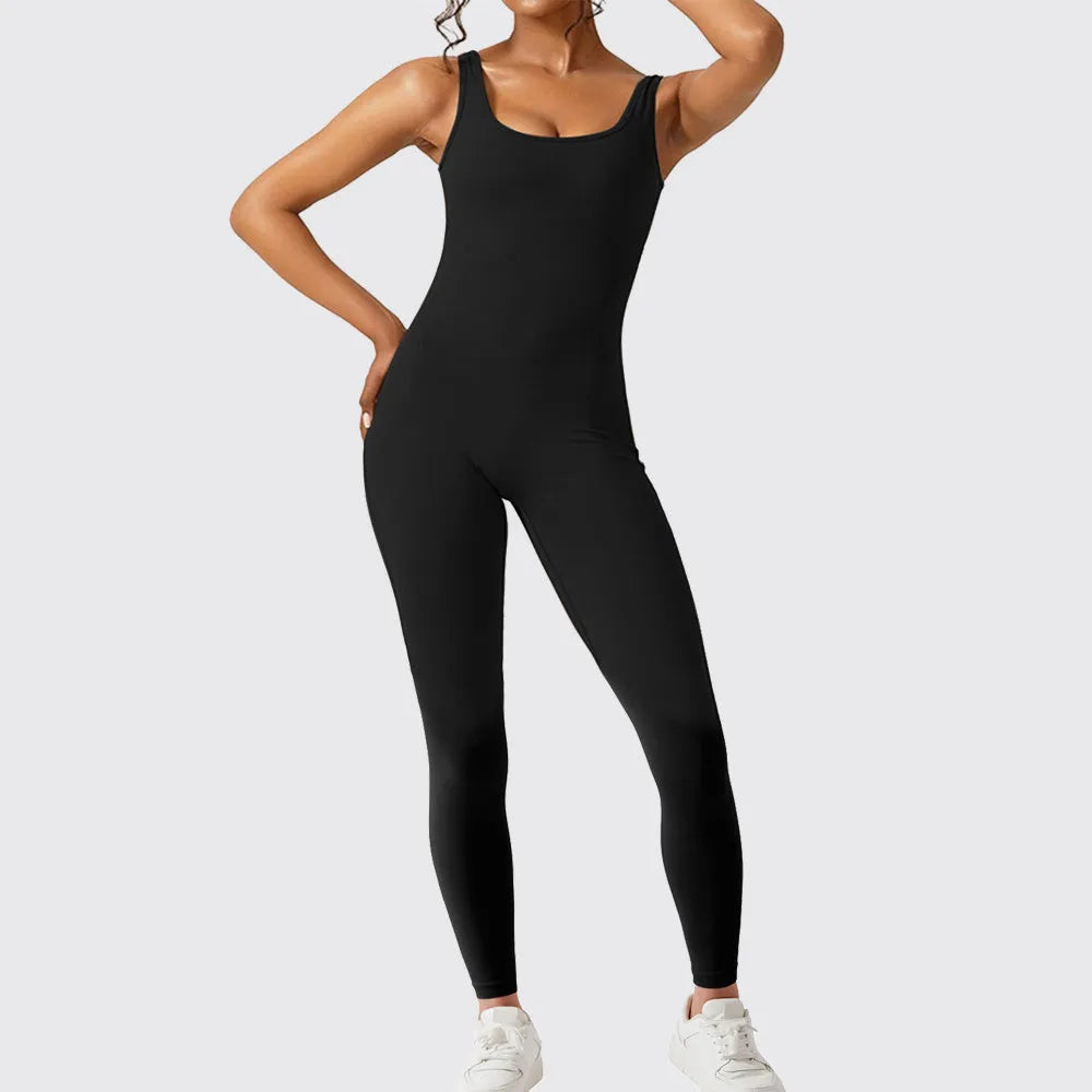 Woman wearing a sleeveless army green flare jumpsuit for yoga, demonstrating the high-elasticity polyester fabric.