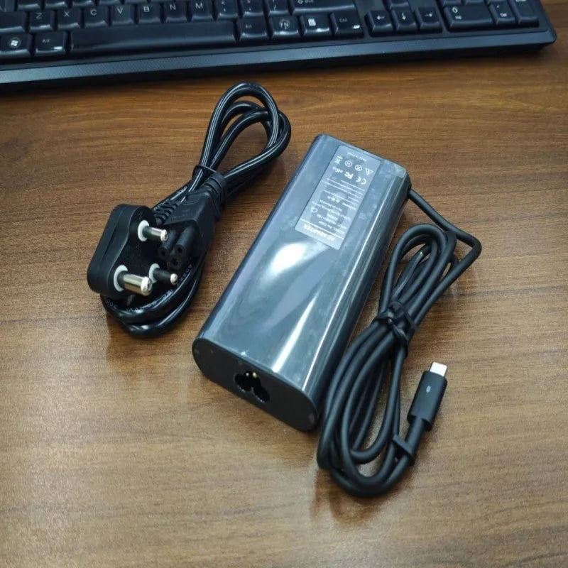 Black 65W Type-C laptop power adapter with six international power cords for worldwide charging