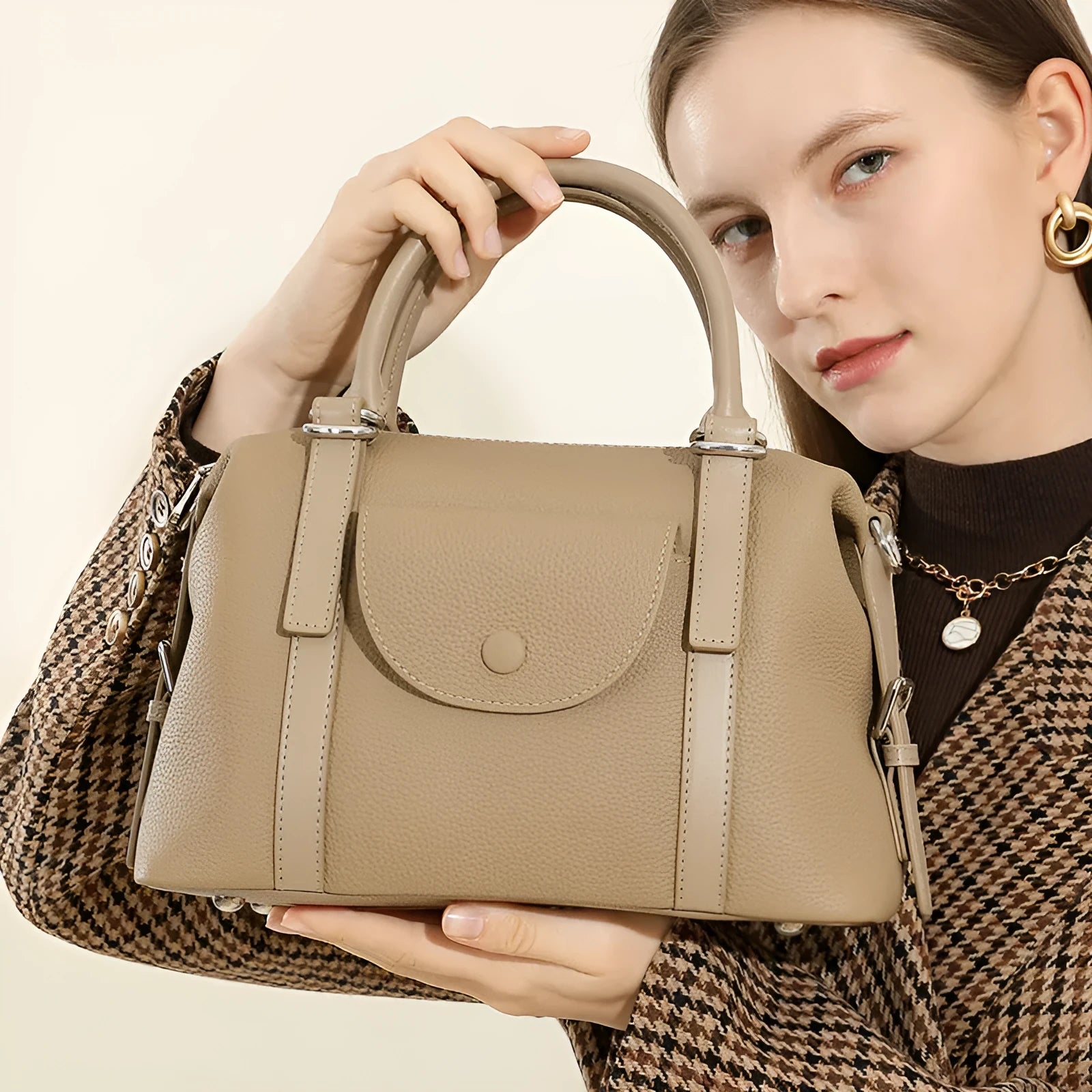 Genuine leather ladies handbag with lock detail in black, brown, or elephant grey.