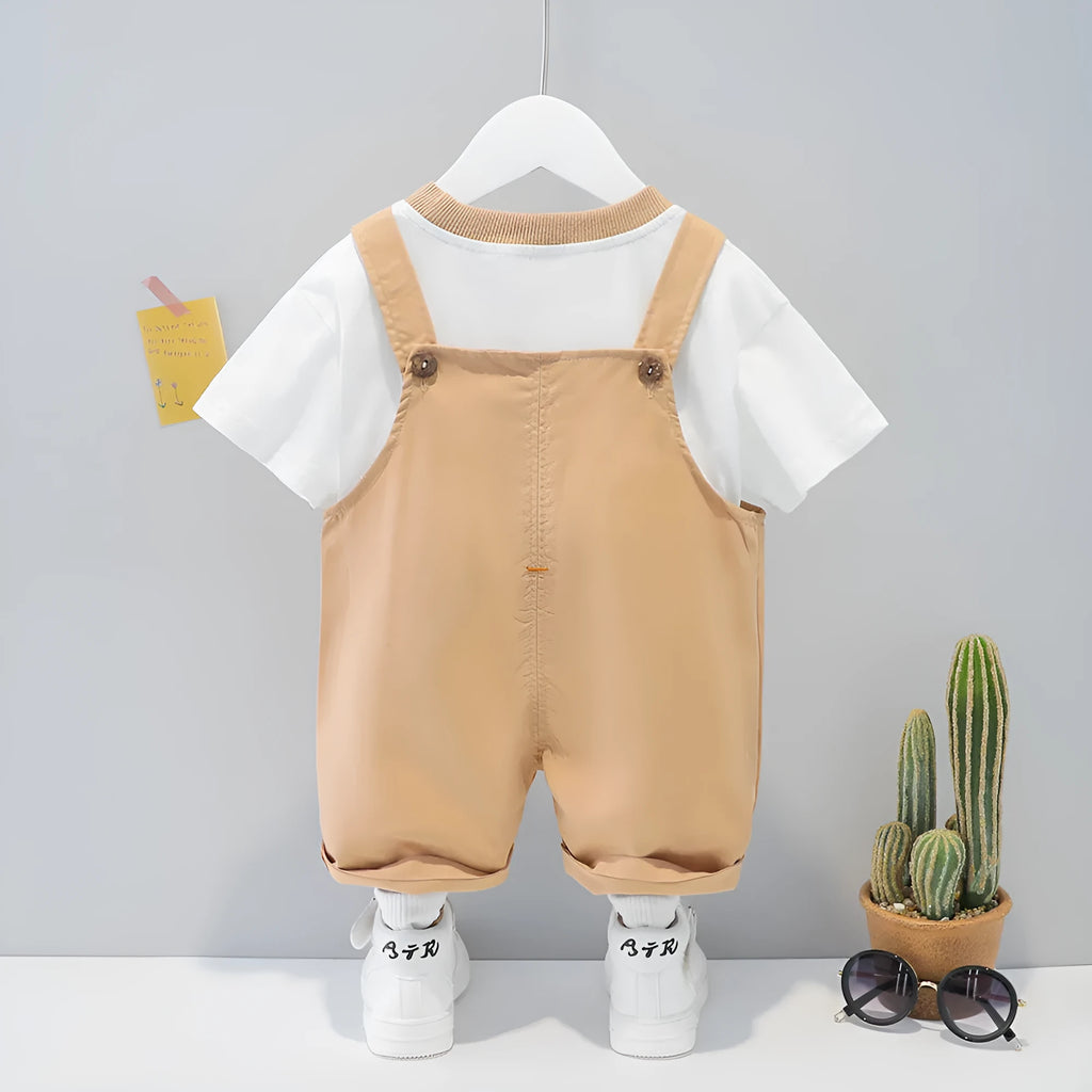 Yellow cartoon short-sleeved overalls for a baby on a hanger, showing the adjustable straps.