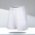 Man wearing loose fit black quick-dry ice silk sports shorts on a beach.