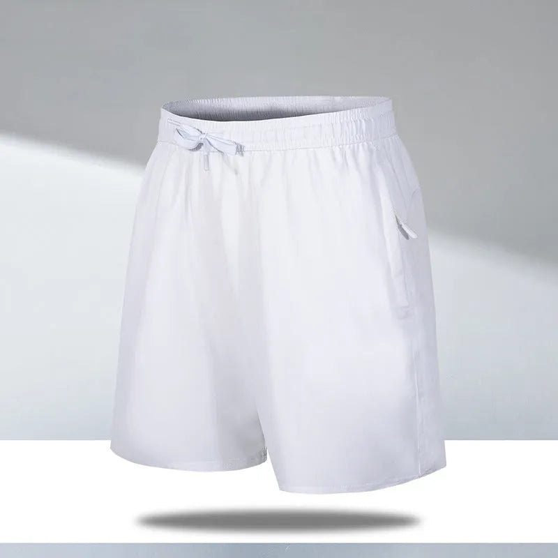 Man wearing loose fit black quick-dry ice silk sports shorts on a beach.