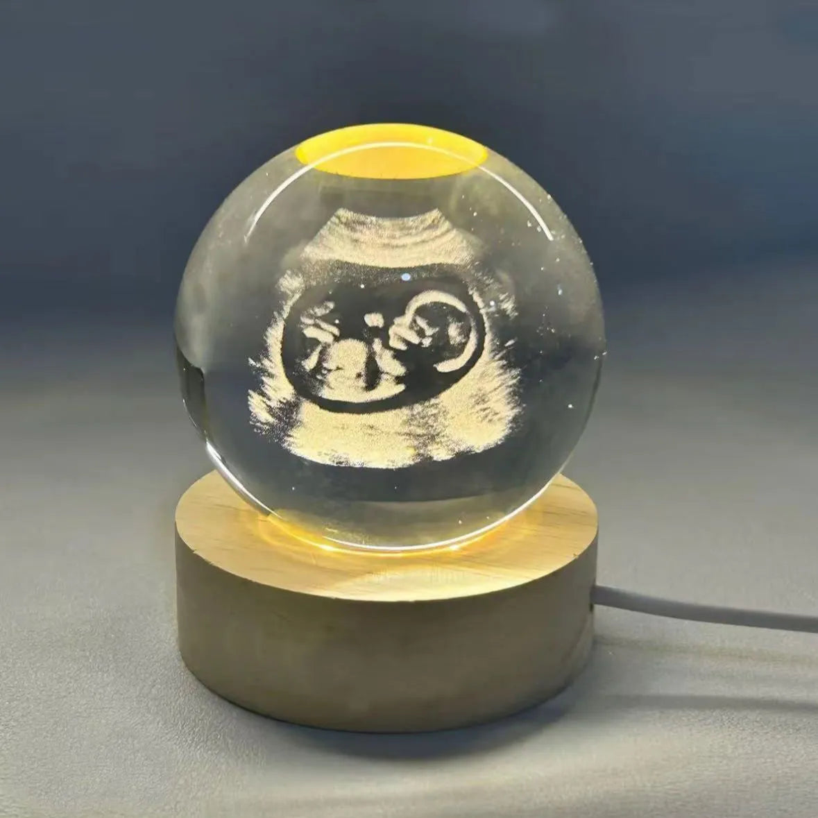 Clear crystal ball night lamp with warm light placed on base, 6cm or 8cm size option available