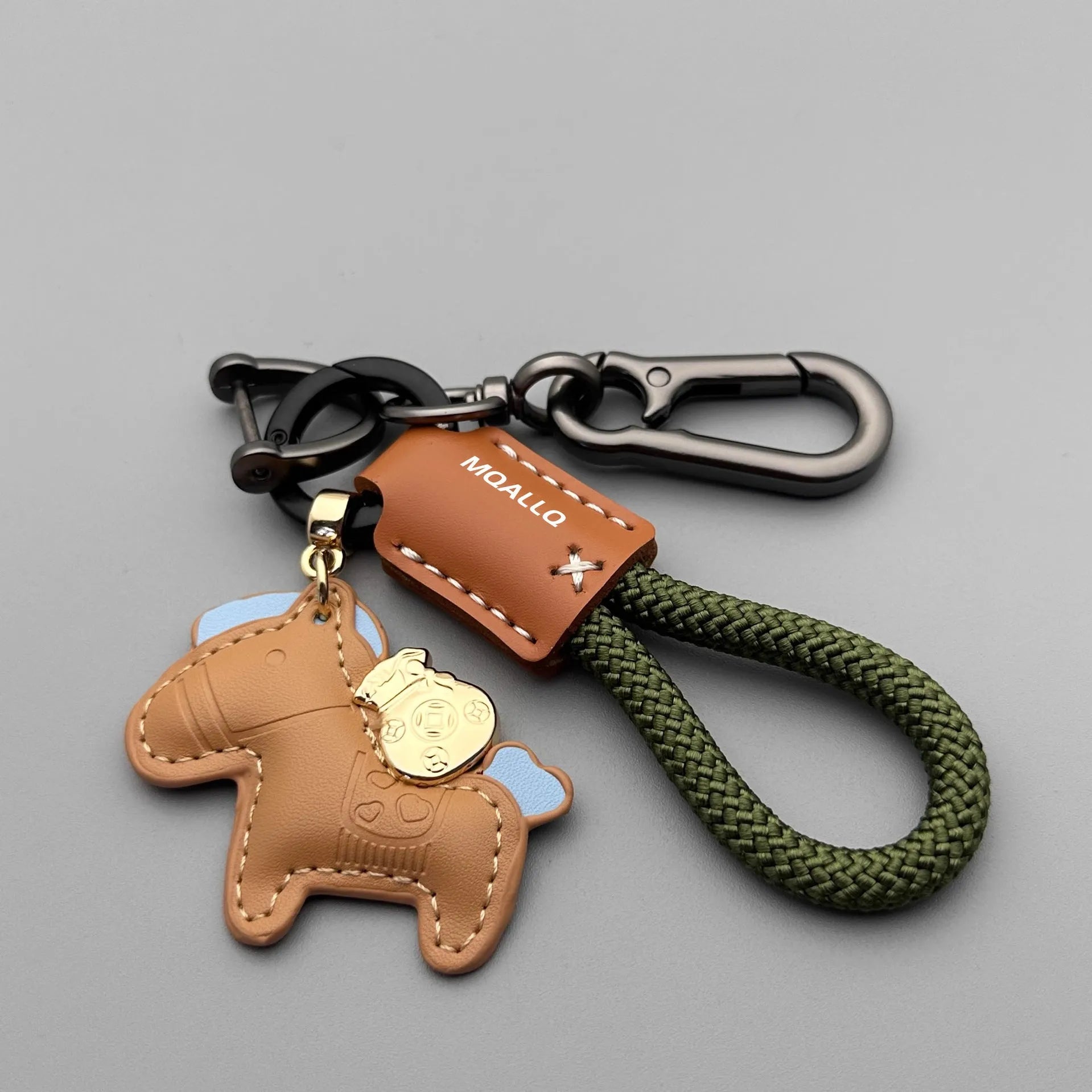 Handmade brown cowhide key pendant with a green flannel rope and a gold-toned horse-shaped buckle.