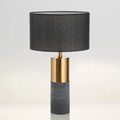 Simple designer industrial style table lamp in dark gray on a wooden desk with ambient lighting