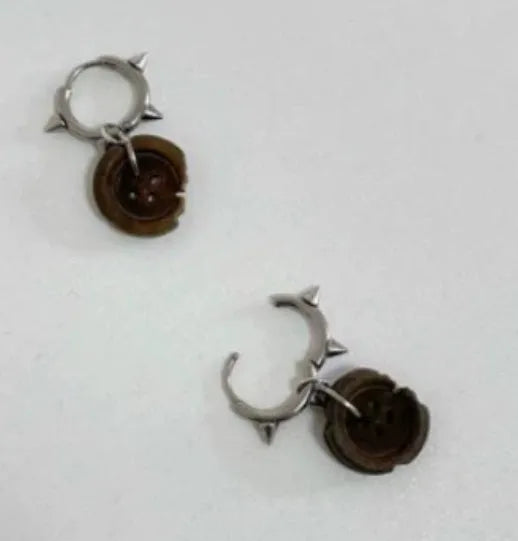 One pair of brown alloy ancient style burned gap button distressed earrings on neutral background