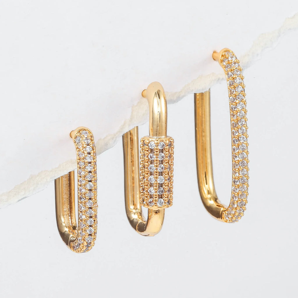 Three geometric ear clips with micro-inlaid zircon stones on copper, showing gold and white gold colour options